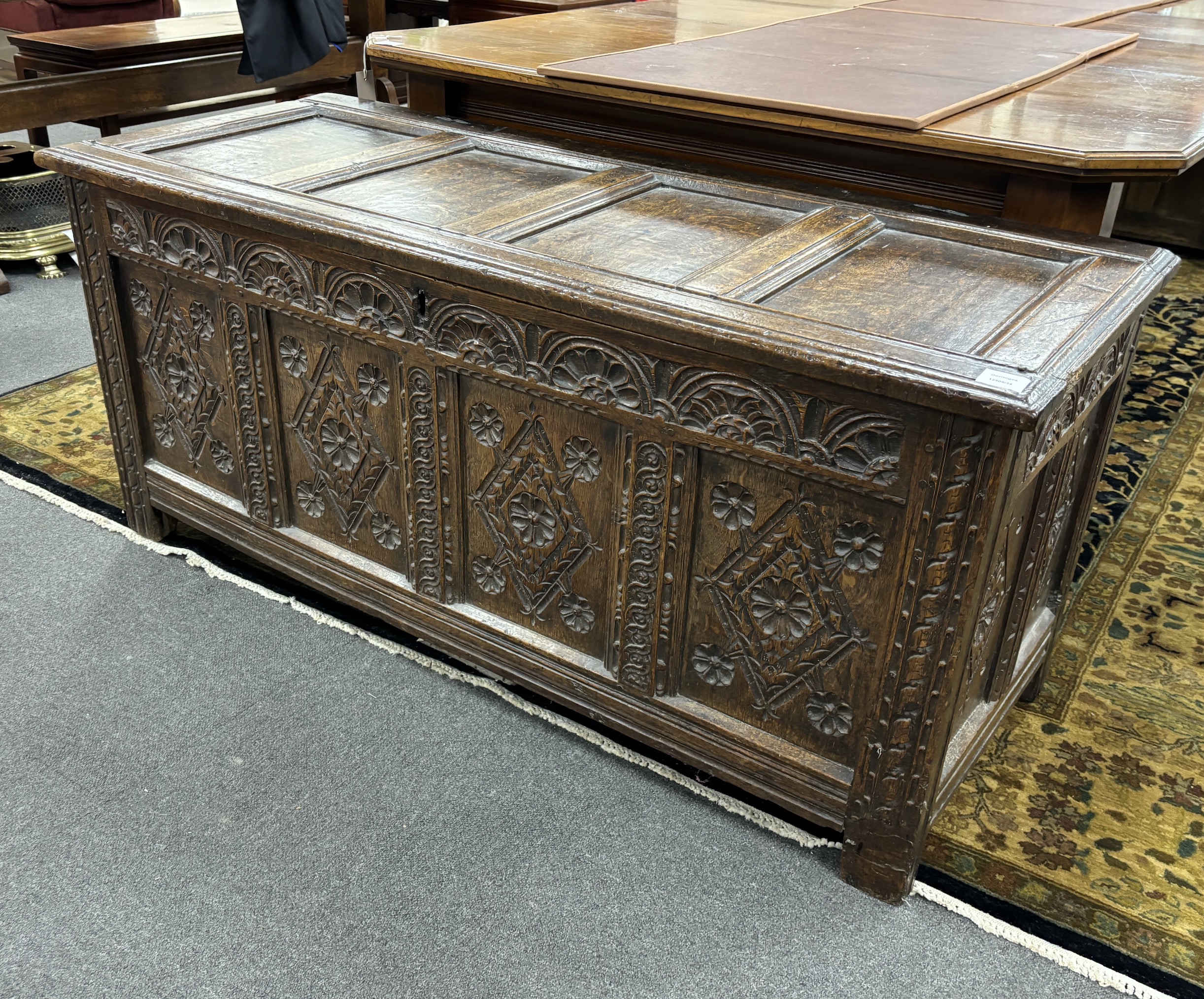 A late 17th century carved oak coffer, the front with four lozenge and rosette panels, beneath a lunette frieze, width 142cm, depth 56cm, height 64cm